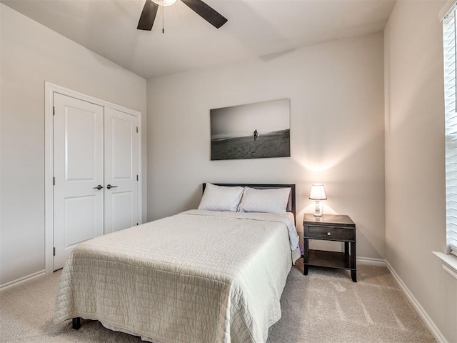 bedroom featuring ceiling fan, light colored carpet, and a closet