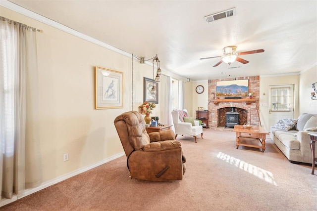 living room featuring carpet, ceiling fan, a wood stove, and ornamental molding