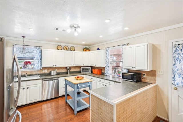 kitchen with white cabinetry, plenty of natural light, hanging light fixtures, and appliances with stainless steel finishes