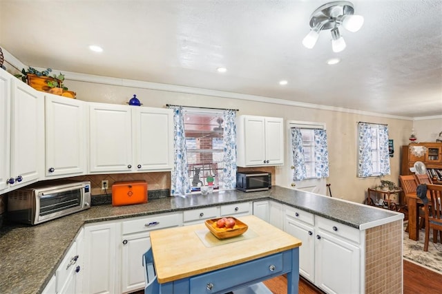 kitchen with a center island, dark hardwood / wood-style flooring, and white cabinetry