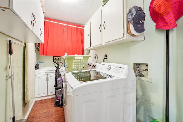 laundry room featuring cabinets, washer and dryer, and dark wood-type flooring