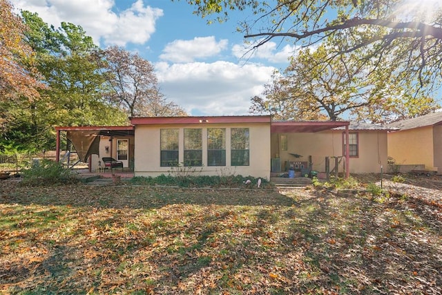 back of house featuring a lawn and a patio