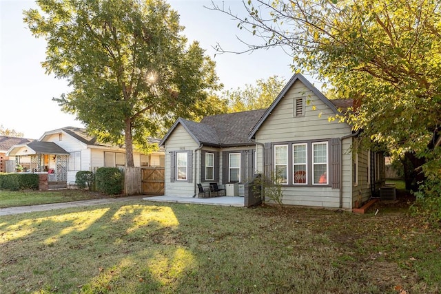 view of front facade featuring a patio, central AC unit, and a front lawn