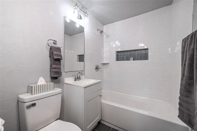 full bathroom featuring a textured ceiling, vanity, tiled shower / bath combo, and toilet