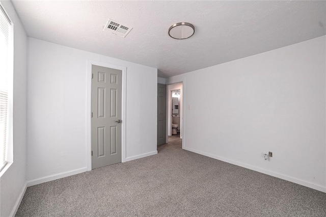 spare room featuring carpet and a textured ceiling