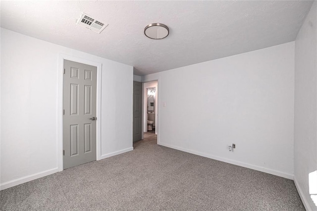 carpeted spare room featuring a textured ceiling