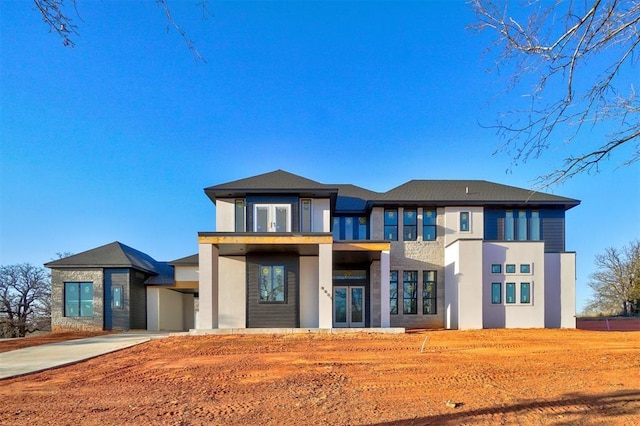 view of front facade with french doors, concrete driveway, and stucco siding