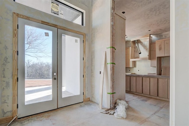 doorway to outside with french doors and wallpapered walls