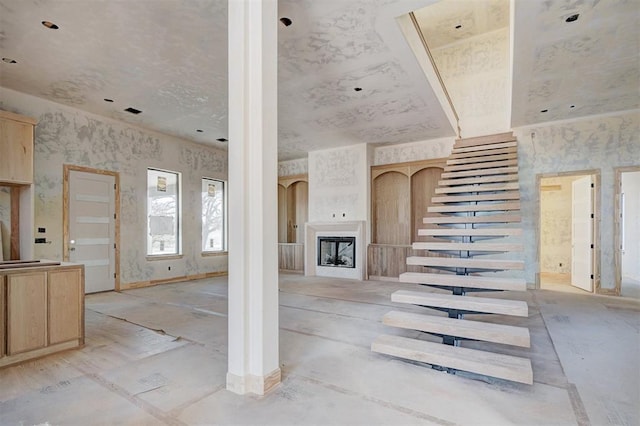 unfurnished living room with a fireplace and stairway