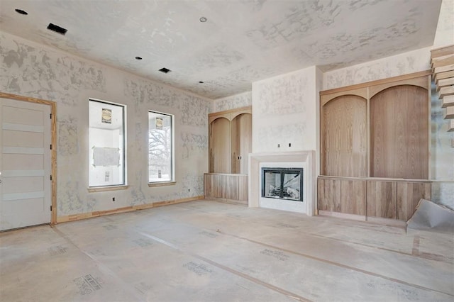 unfurnished living room with a fireplace and baseboards