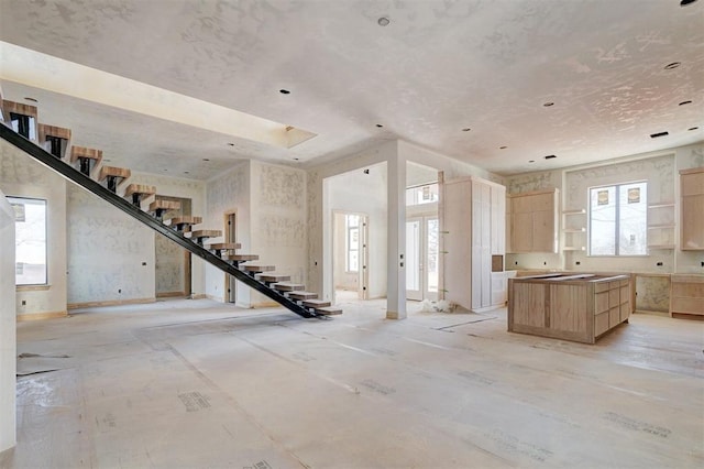 kitchen with a center island, open floor plan, open shelves, and light brown cabinetry