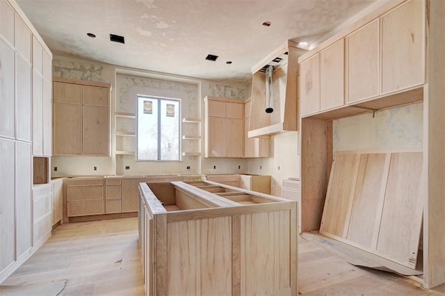 kitchen featuring light wood-type flooring, light brown cabinets, and a kitchen island