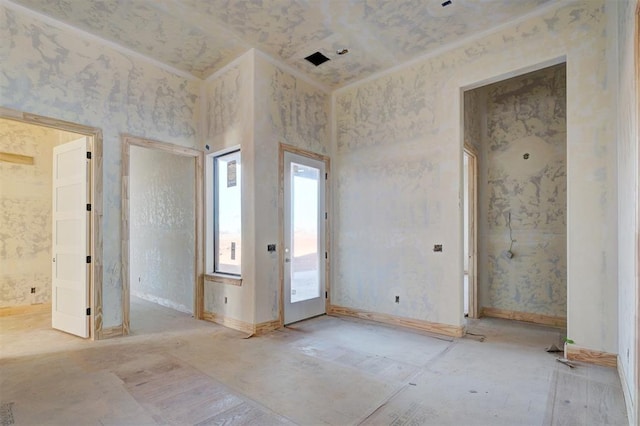 unfurnished room featuring wallpapered walls, baseboards, and crown molding