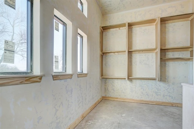 unfurnished room featuring unfinished concrete flooring and baseboards