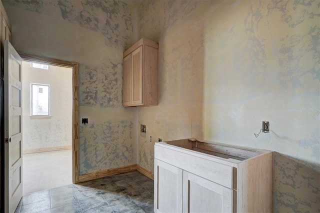 bathroom featuring baseboards and wallpapered walls