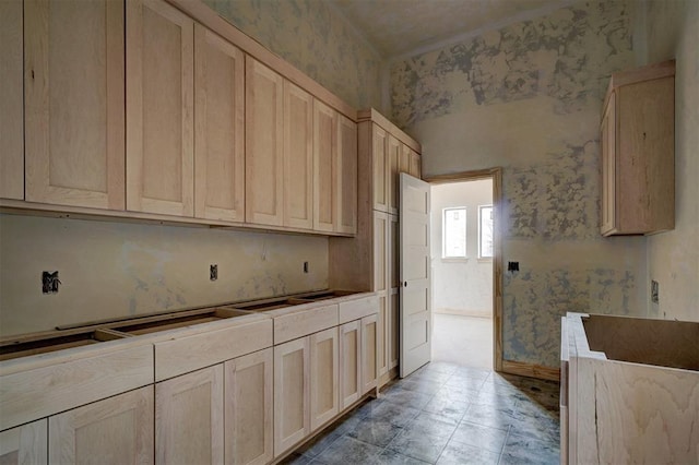 kitchen with light brown cabinetry and wallpapered walls