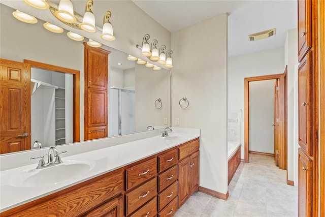 bathroom featuring tile patterned flooring, vanity, and shower with separate bathtub