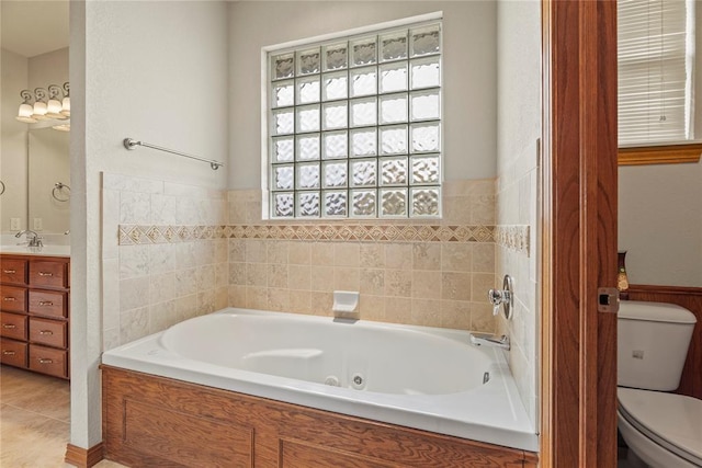 bathroom featuring a tub to relax in, vanity, and toilet