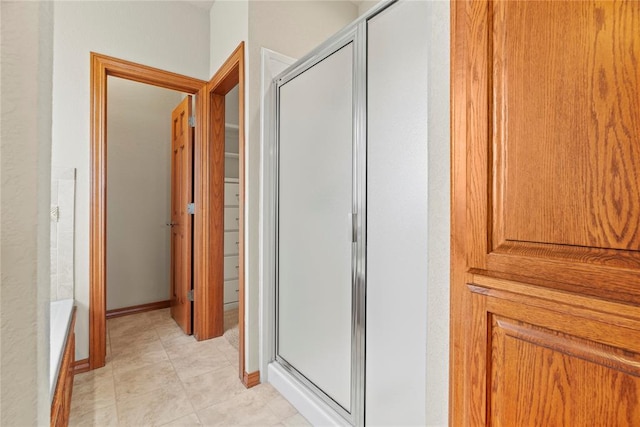 bathroom with tile patterned flooring and a shower with shower door