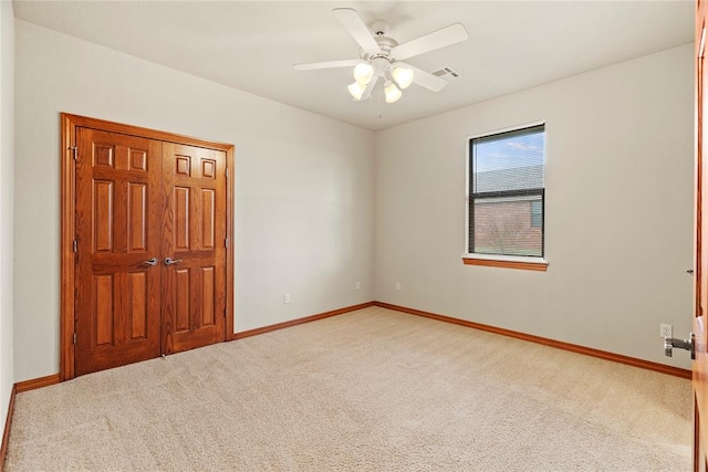 carpeted spare room featuring ceiling fan