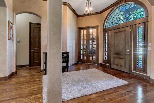 entrance foyer featuring french doors, dark hardwood / wood-style floors, and ornamental molding