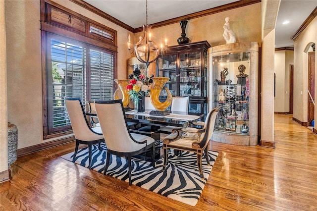 dining room with light hardwood / wood-style floors, ornamental molding, and a chandelier