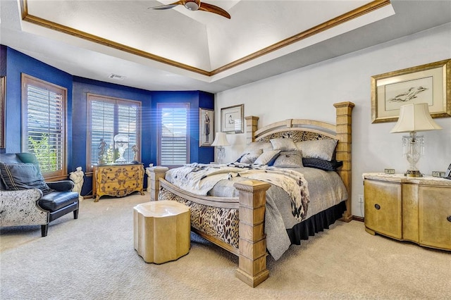 carpeted bedroom featuring a raised ceiling, ceiling fan, and ornamental molding