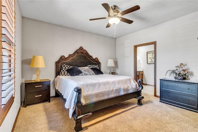 bedroom featuring light colored carpet, ensuite bath, and ceiling fan