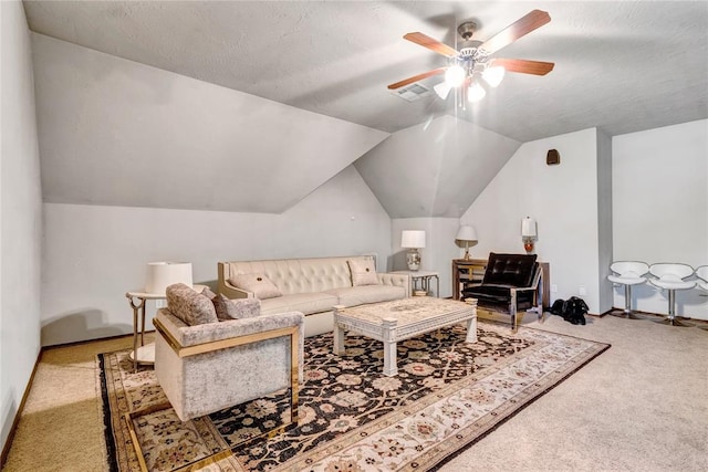 living room featuring lofted ceiling, ceiling fan, carpet floors, and a textured ceiling