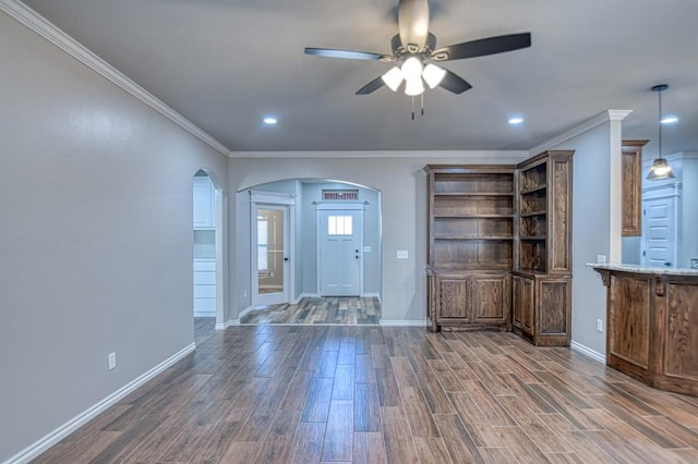 interior space with dark hardwood / wood-style flooring, ceiling fan, and crown molding