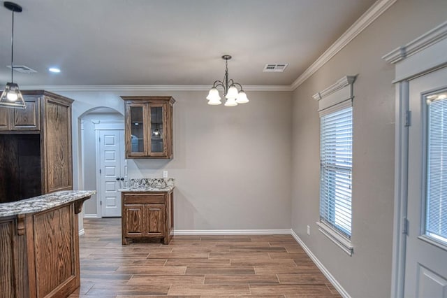 kitchen with a chandelier, decorative light fixtures, light hardwood / wood-style floors, and crown molding