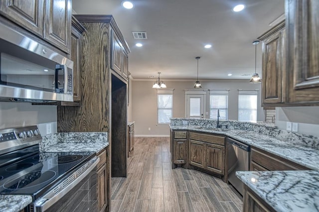 kitchen featuring a healthy amount of sunlight, crown molding, dark wood-type flooring, and appliances with stainless steel finishes