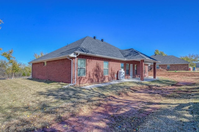 rear view of property featuring a patio area and a yard