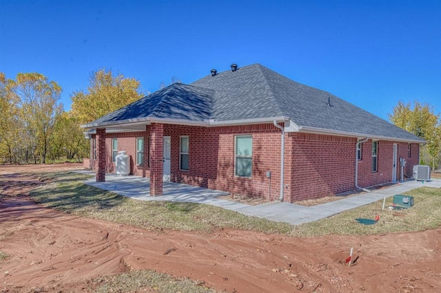 view of side of property featuring cooling unit and a patio area