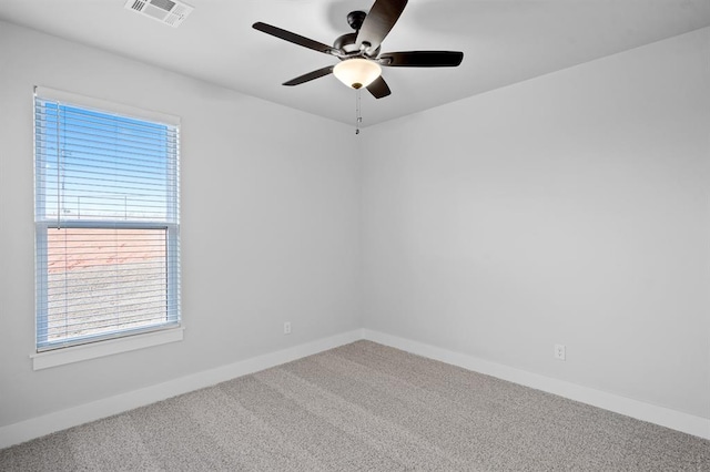 carpeted spare room featuring ceiling fan and a healthy amount of sunlight