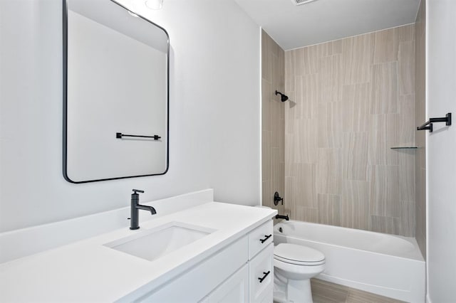 full bathroom featuring vanity, toilet, and tiled shower / bath