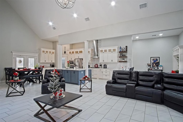 living room with light tile patterned floors, high vaulted ceiling, and a chandelier