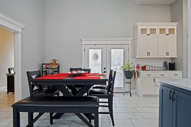 tiled dining area featuring french doors