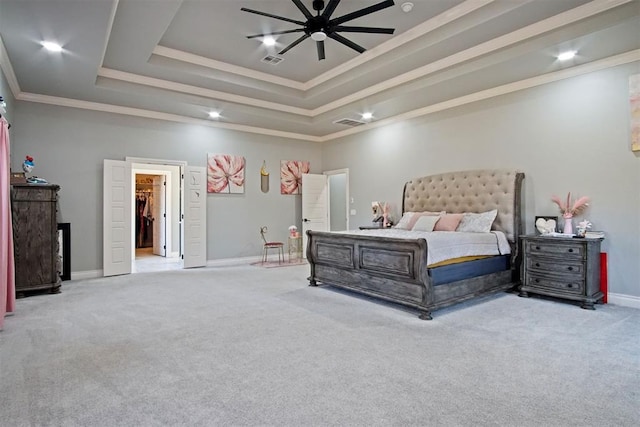 carpeted bedroom featuring a raised ceiling, ceiling fan, crown molding, a spacious closet, and a closet