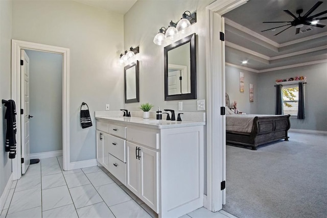 bathroom with vanity, a raised ceiling, ceiling fan, and crown molding