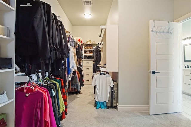 walk in closet featuring light carpet