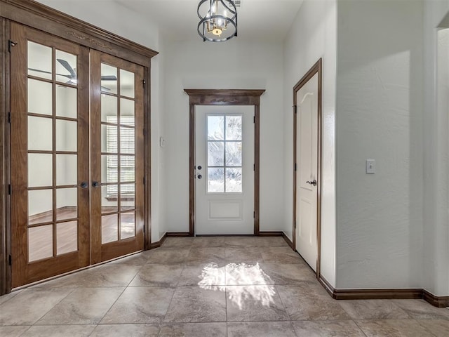 doorway to outside featuring a chandelier and french doors