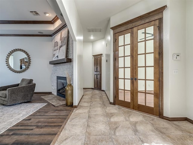 hall featuring crown molding, light hardwood / wood-style flooring, and french doors