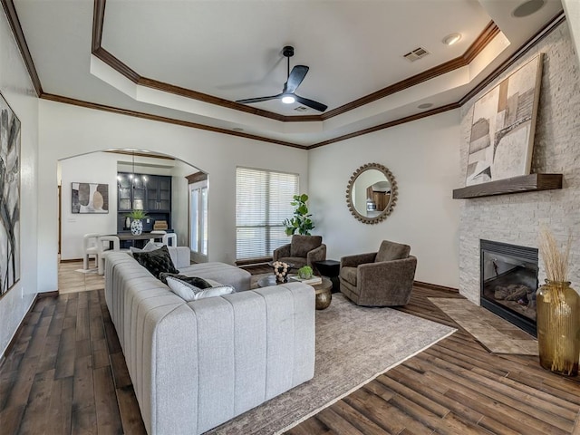 living room with crown molding, ceiling fan with notable chandelier, and dark hardwood / wood-style floors