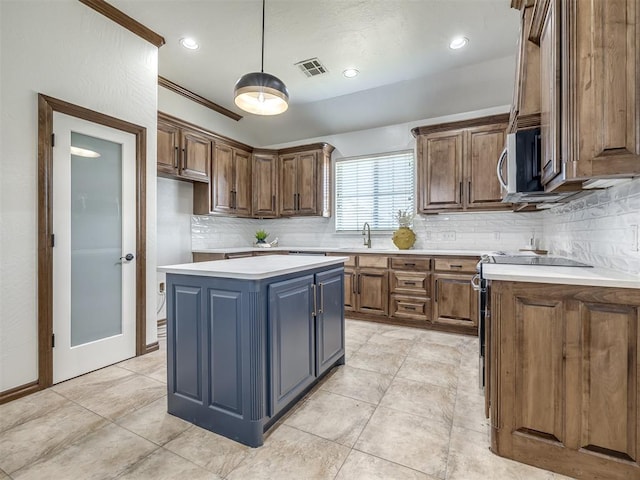 kitchen with a center island, sink, backsplash, crown molding, and pendant lighting