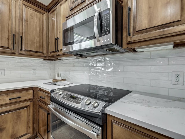 kitchen featuring stainless steel appliances and tasteful backsplash