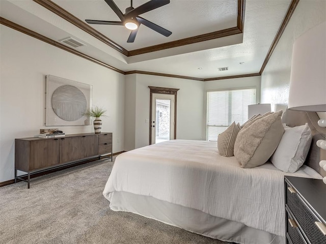 bedroom with a tray ceiling, ceiling fan, crown molding, and light carpet