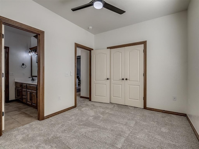 unfurnished bedroom with light carpet, connected bathroom, a closet, and ceiling fan