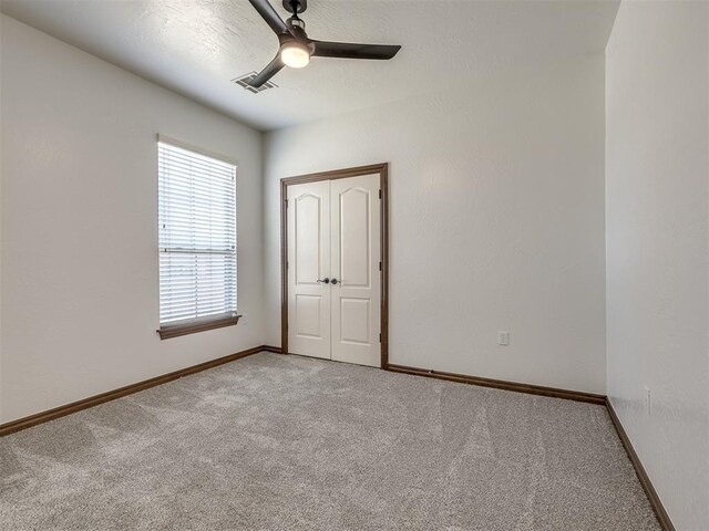 unfurnished room featuring ceiling fan and light colored carpet