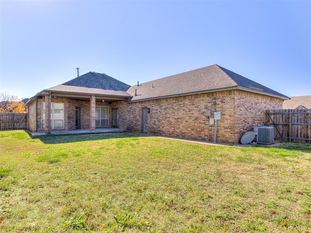 rear view of property with a yard and cooling unit